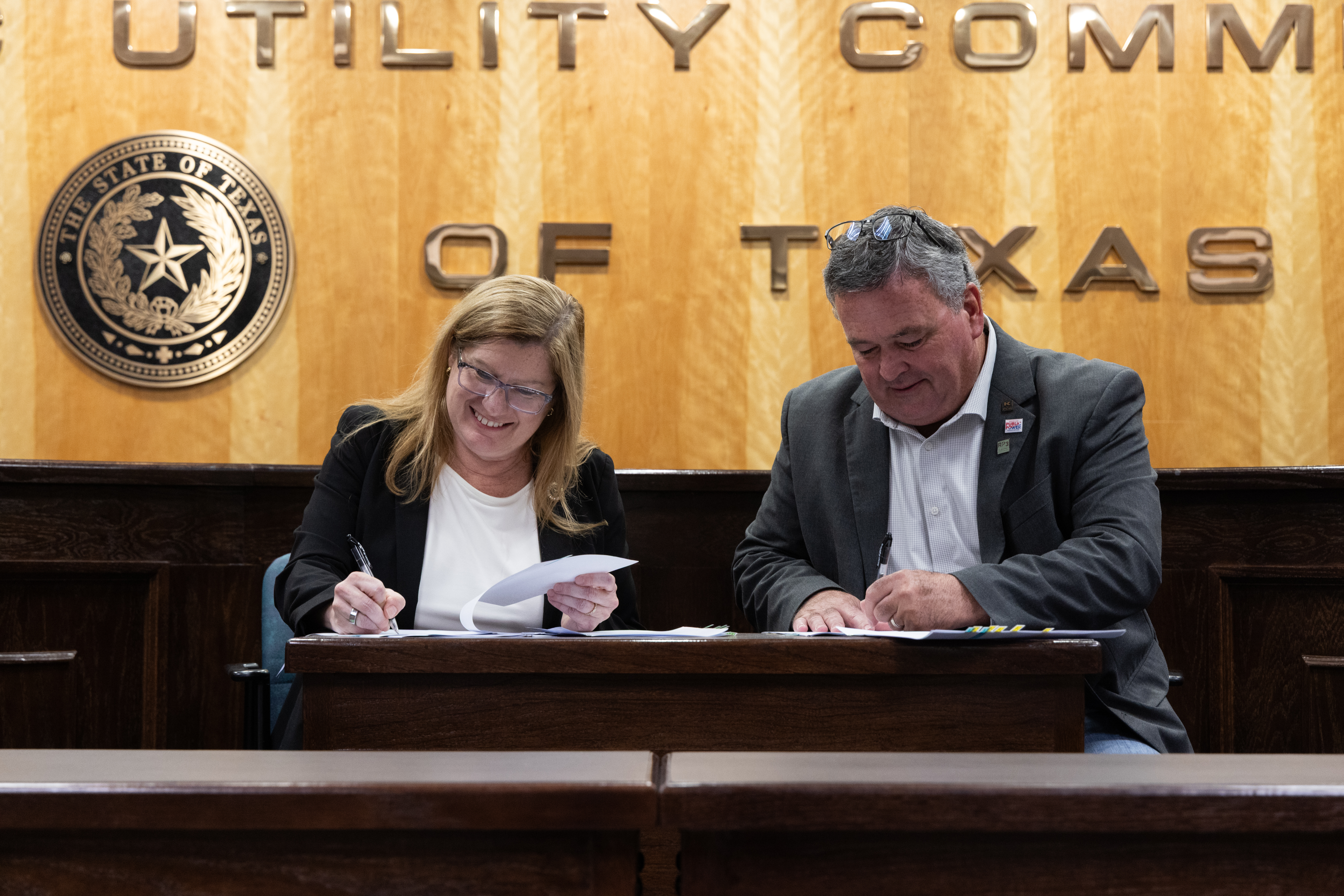 KPUB CEO Mike Wittler and PUCT Executive Director Connie Corona commemorate history as they sign the first Texas Energy Fund loan agreement on June 25, 2025, in Austin.