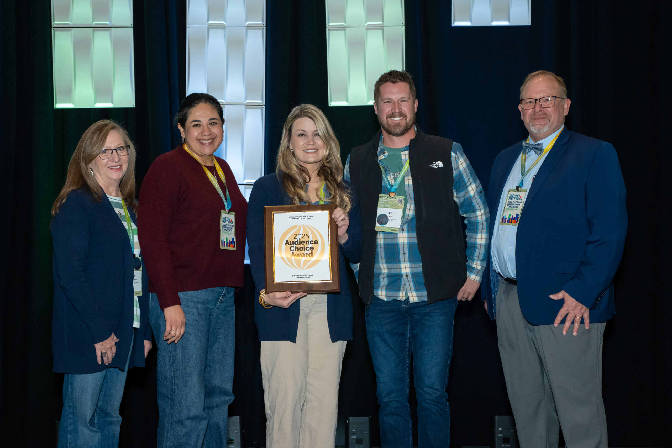 KPUB receives national Audience Choice Award: (L–R) Jo Anderson, KPUB Supervisor of Customer Service; Asha Ramirez, KPUB Customer Service Representative Lead Coordinator; Allison Bueche, KPUB Director of Customer & Community Relations; DJ Owens, KPUB Energy Services Manager; and an APPA representative. Bueche, center, holds KPUB’s Audience Choice Award, presented for the utility’s video after the Hill Country Flood, titled, “When the Guadalupe River Rose, We Rose, Too.” 